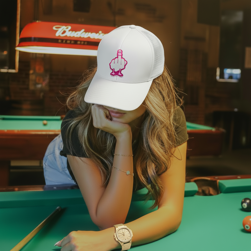Mujer con gorra blanca y logo rosa en estilo urbano streetwear, look moderno en mesa de billar.