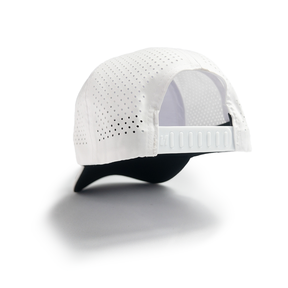 Gorra blanca perforada Duck U vista diagonal con cierre snapback y panel de ventilación.